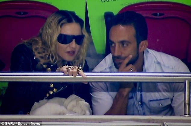 Madonna gets close to mystery male pal as she takes football fanatic son David to Portugal match