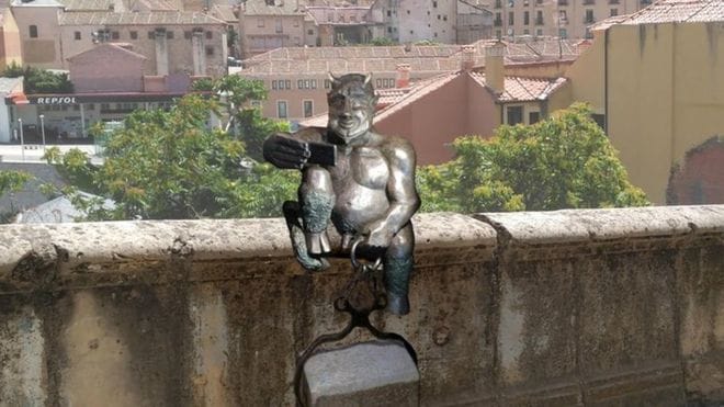 A statue of the devil smiling, taking a selfie caused controversy in Spain